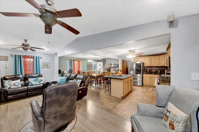 a kitchen with stainless steel appliances granite countertop a sink dishwasher stove and refrigerator with wooden floor