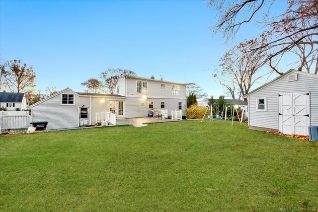 a view of a white house in middle of the green field