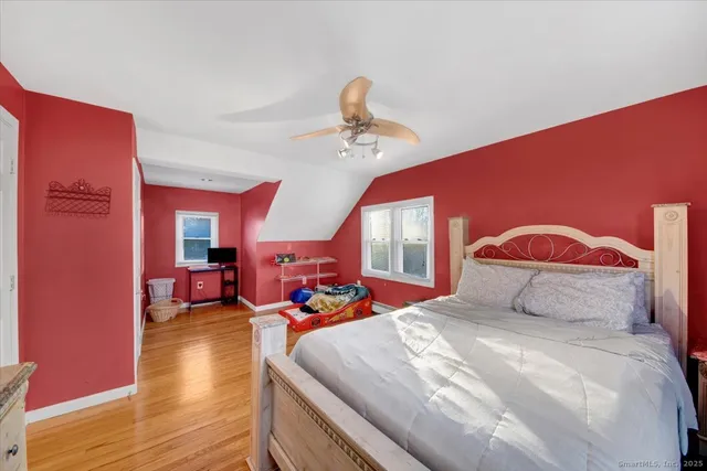 a bedroom with a bed and wooden floor