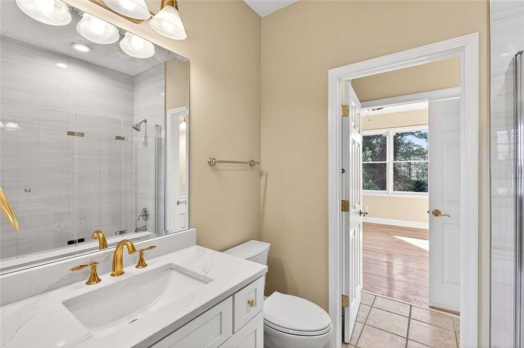 3316 Keenland Road Marietta, GA 30062 - Photo 35 of 57 a bathroom with a sink a toilet a mirror and shower