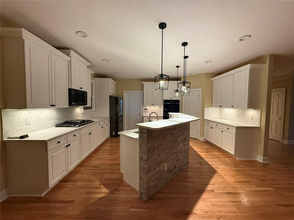 3316 Keenland Road Marietta, GA 30062 - Photo 9 of 54 a large kitchen with stainless steel appliances kitchen island granite countertop a sink a stove top oven a counter space and cabinets