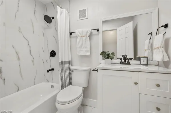a bathroom with a granite countertop sink a toilet and a bathtub