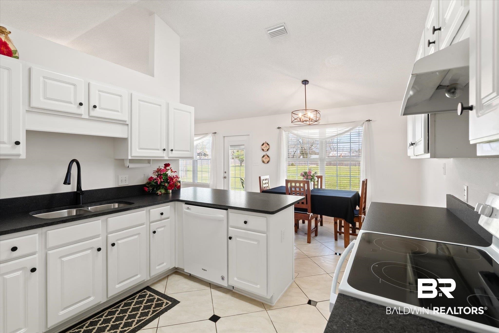 12520 Hunters Chase Foley, AL 36535 - Photo 22 of 32 Kitchen with electric range, white dishwasher, a sink, under cabinet range hood, and dark countertops