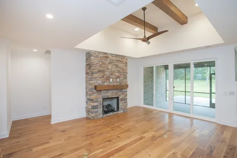 a view of an empty room with a fireplace and a window