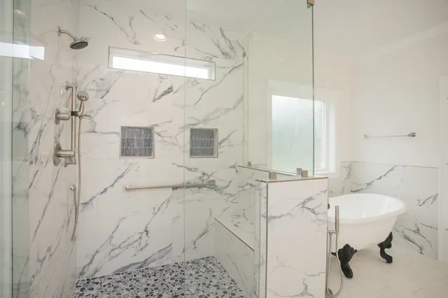 a bathroom with a sink shower and a mirror