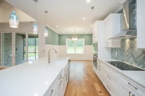 a large white kitchen with a large window