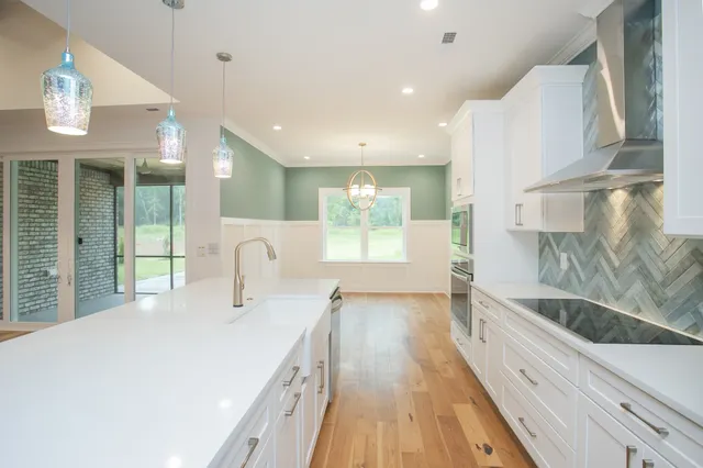 a large white kitchen with a large window