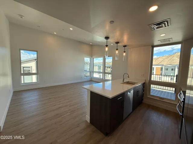 a large kitchen with kitchen island a sink dishwasher a dining table and chairs with wooden floor