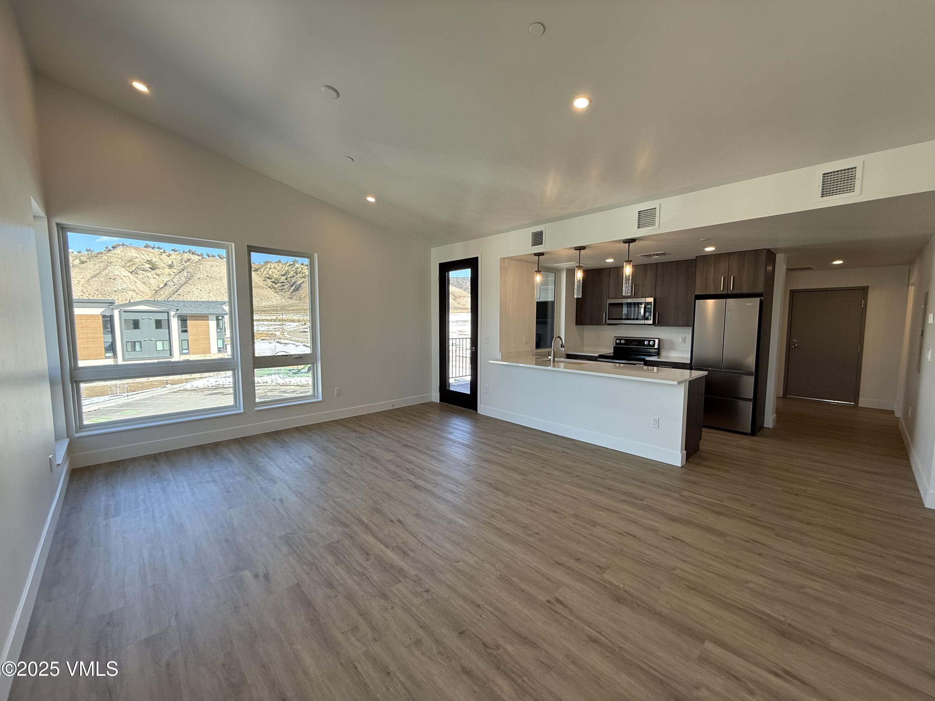 91 Mount Hope Circle, Unit G301 Eagle, CO 81631 - Photo 5 of 13 a view of a kitchen center island wooden floor and stainless steel appliances