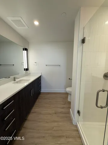 a spacious bathroom with a double vanity sink a toilet and a shower