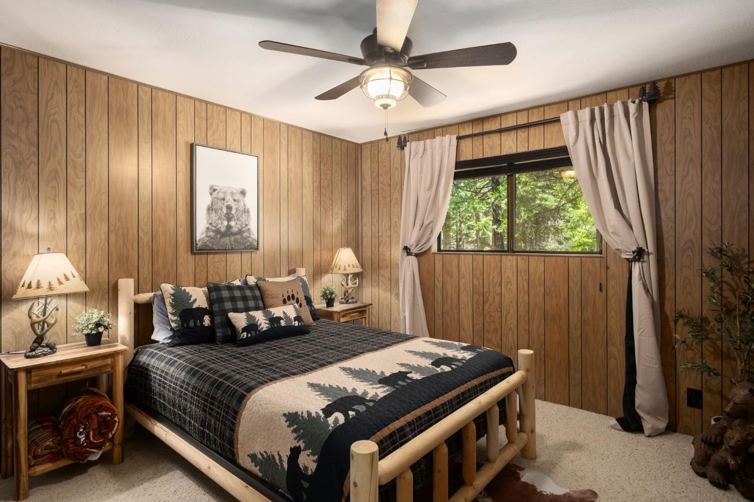 42488 Rock Ledge Road Shaver Lake, CA 93664 - Photo 21 of 26 a bedroom with a bed and a chandelier