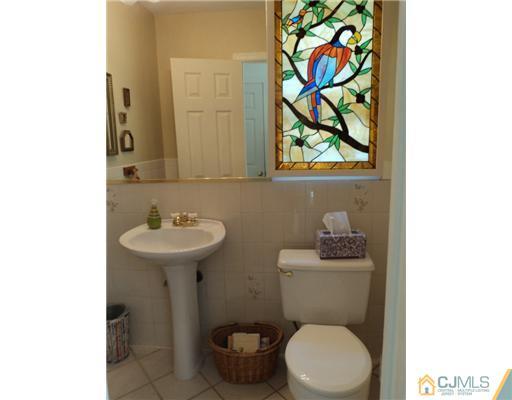 17 Woodlot Road East Brunswick, NJ 08816 - Photo 12 of 25 a bathroom with a toilet sink and mirror