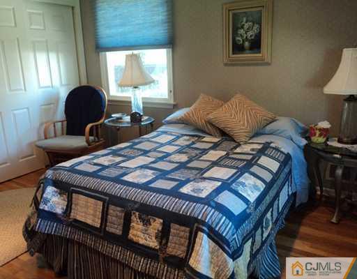 17 Woodlot Road East Brunswick, NJ 08816 - Photo 18 of 25 a bedroom with a bed table chair and a window