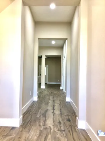 a view of a hallway with wooden shelves