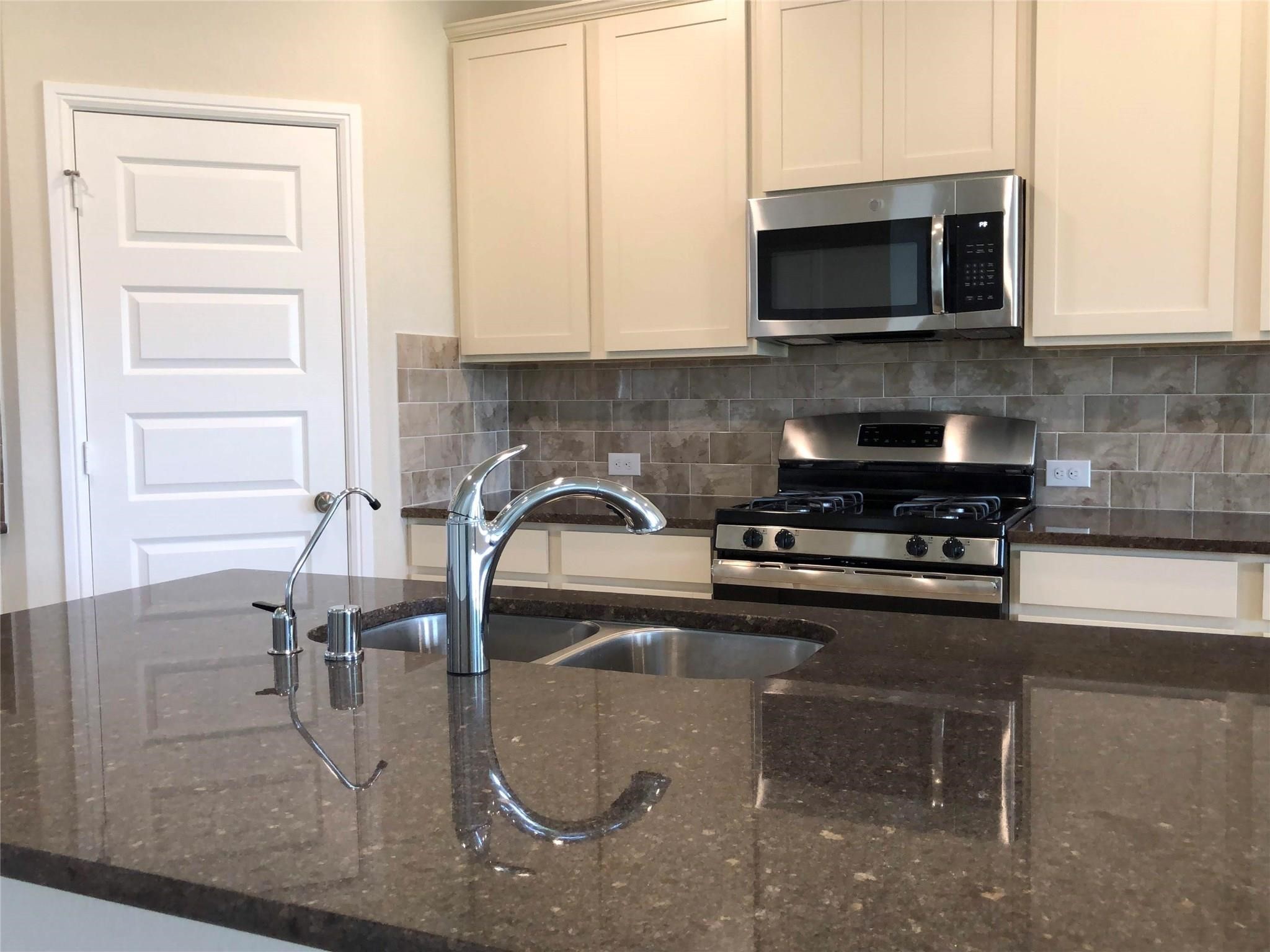 3822 Supremes Trail Spring, TX 77386 - Photo 36 of 40 a kitchen with a sink a microwave and cabinets