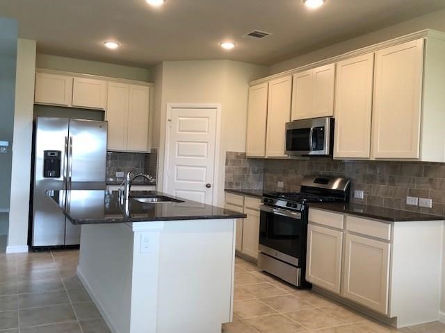 3822 Supremes Trail Spring, TX 77386 - Photo 37 of 40 a kitchen with stainless steel appliances granite countertop a refrigerator a stove a sink and a microwave