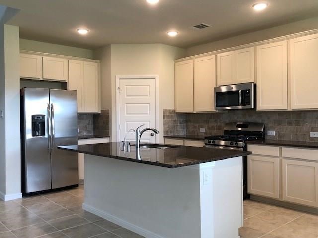 3822 Supremes Trail Spring, TX 77386 - Photo 38 of 40 a kitchen with stainless steel appliances granite countertop a refrigerator a sink a stove a microwave and wooden cabinets