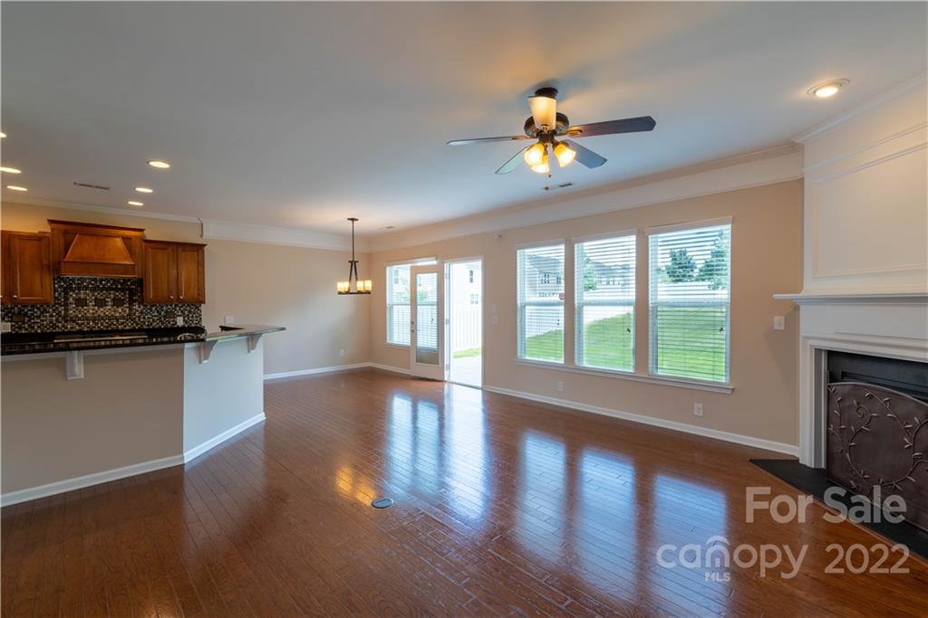 8115 Red Water Road Charlotte, NC 28277 - Photo 13 of 25 a view of an empty room with wooden floor and a kitchen