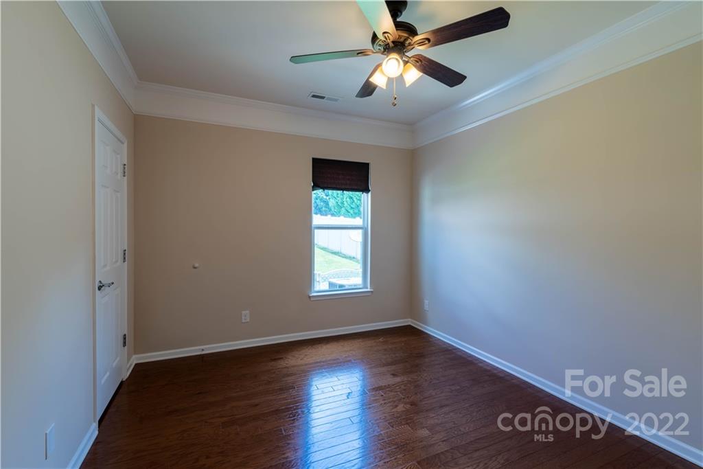 8115 Red Water Road Charlotte, NC 28277 - Photo 18 of 25 an empty room with wooden floor ceiling fan and windows