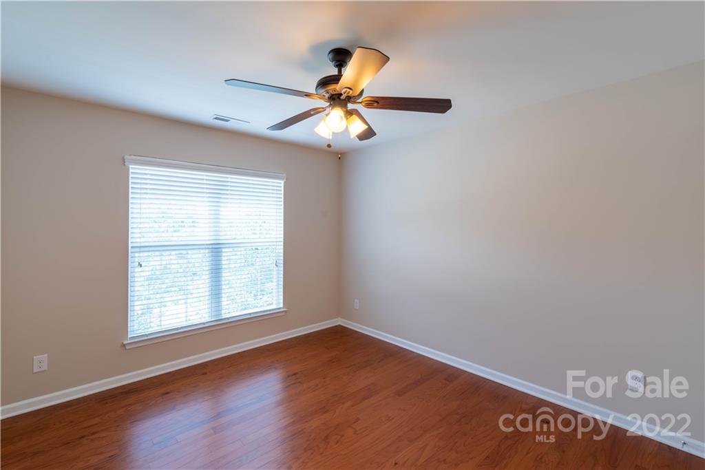 8115 Red Water Road Charlotte, NC 28277 - Photo 20 of 25 an empty room with wooden floor ceiling fan and window
