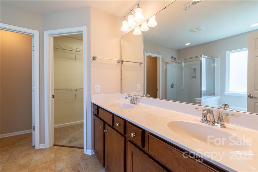 8115 Red Water Road Charlotte, NC 28277 - Photo 21 of 25 a bathroom with a granite countertop sink a large mirror and a shower