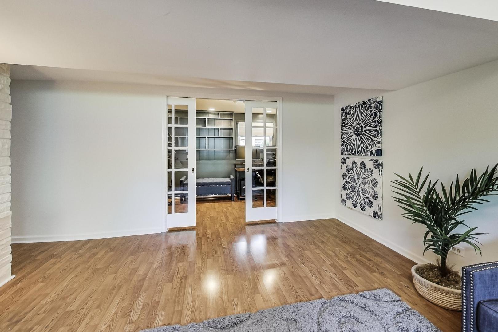 1340 Pendleton Lane Glenview, IL 60025 - Photo 27 of 39 a view of an empty room with wooden floor and a potted plant