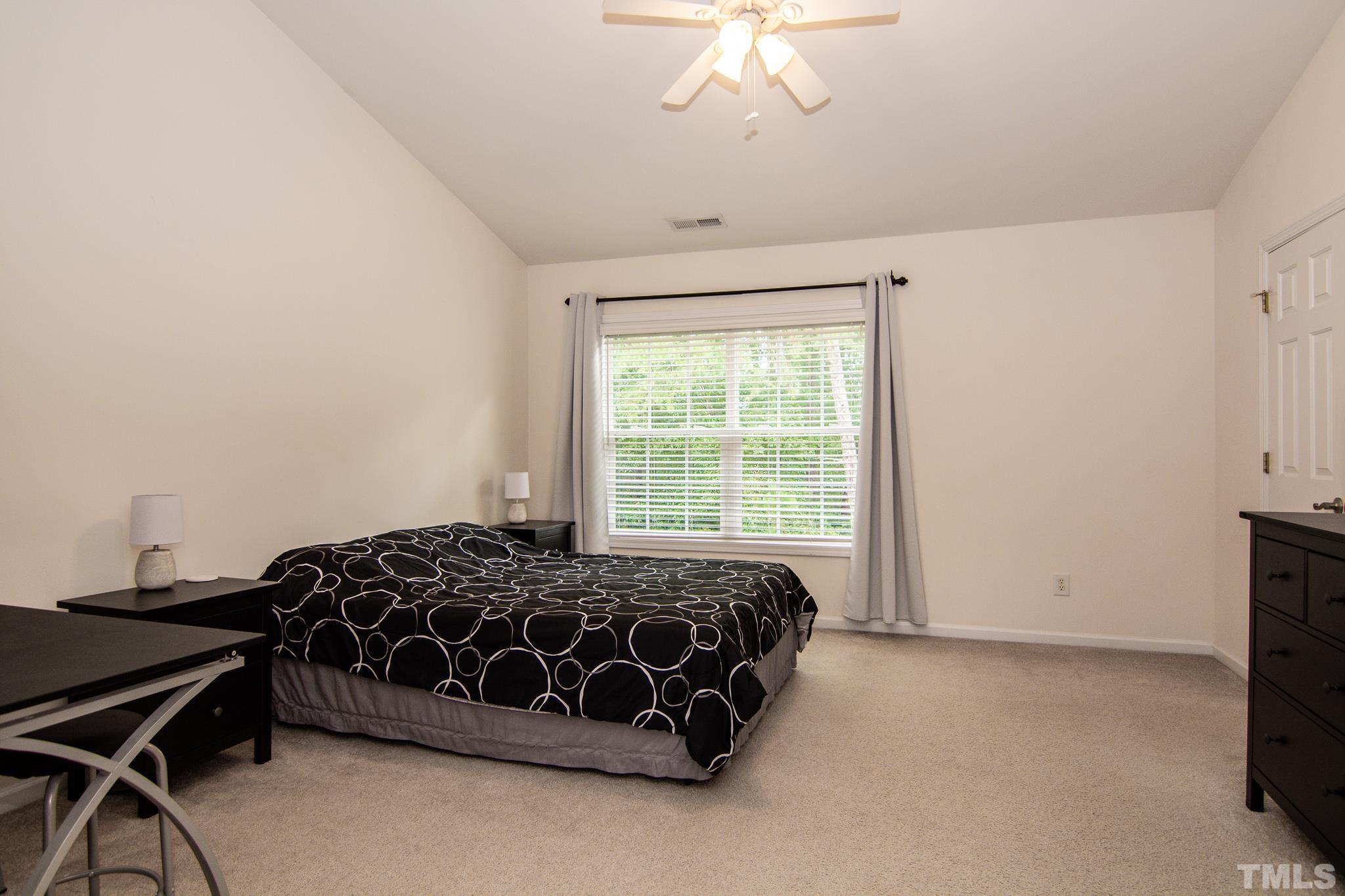 8120 Upper Lake Drive Raleigh, NC 27615 - Photo 14 of 29 a bedroom with a bed and a chandelier