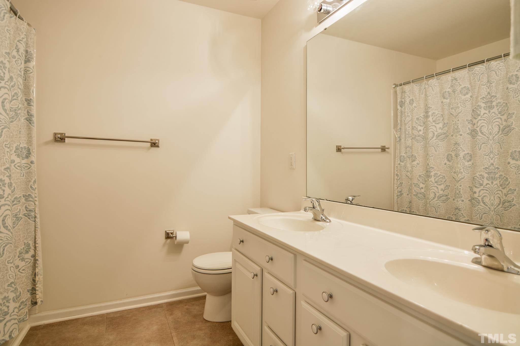 8120 Upper Lake Drive Raleigh, NC 27615 - Photo 15 of 29 a bathroom with a granite countertop sink a toilet and a mirror