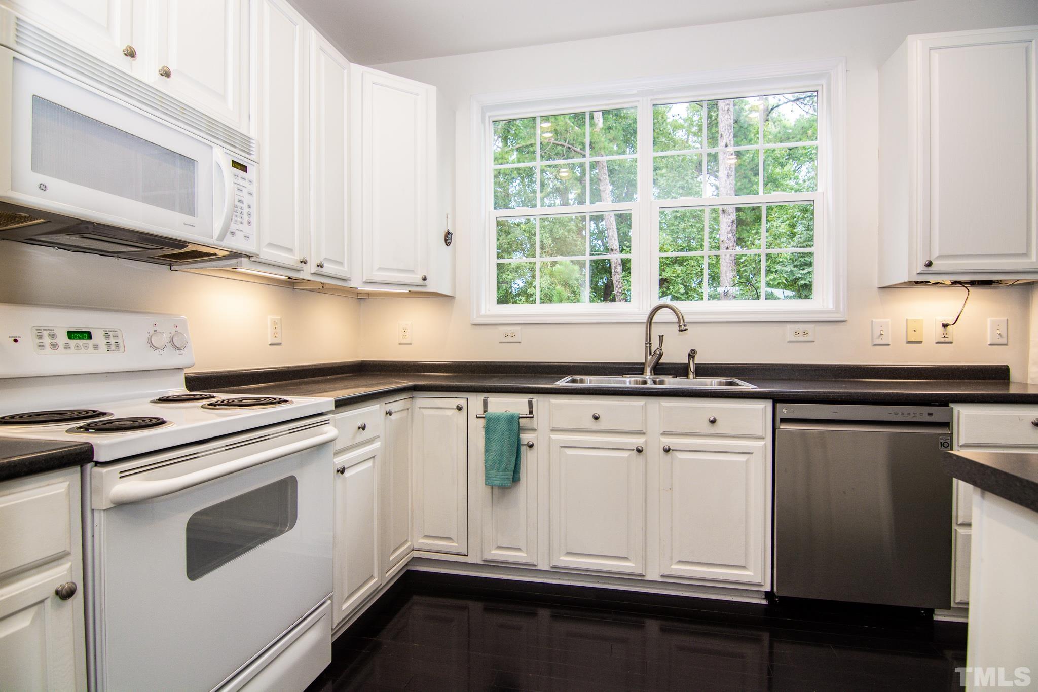 8120 Upper Lake Drive Raleigh, NC 27615 - Photo 5 of 29 a kitchen with granite countertop white cabinets and white appliances
