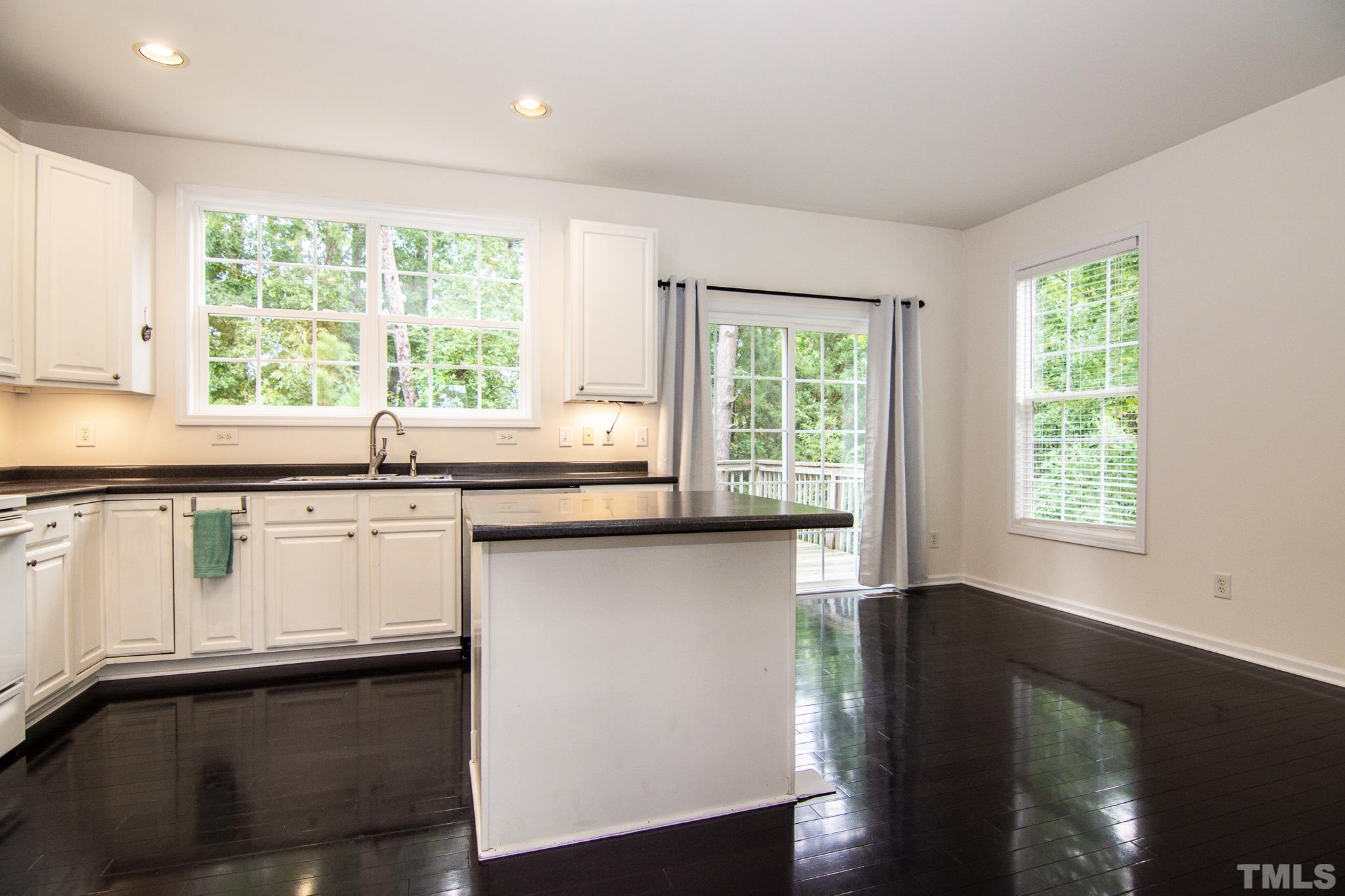 8120 Upper Lake Drive Raleigh, NC 27615 - Photo 6 of 29 a kitchen with stainless steel appliances white cabinets and wooden floor