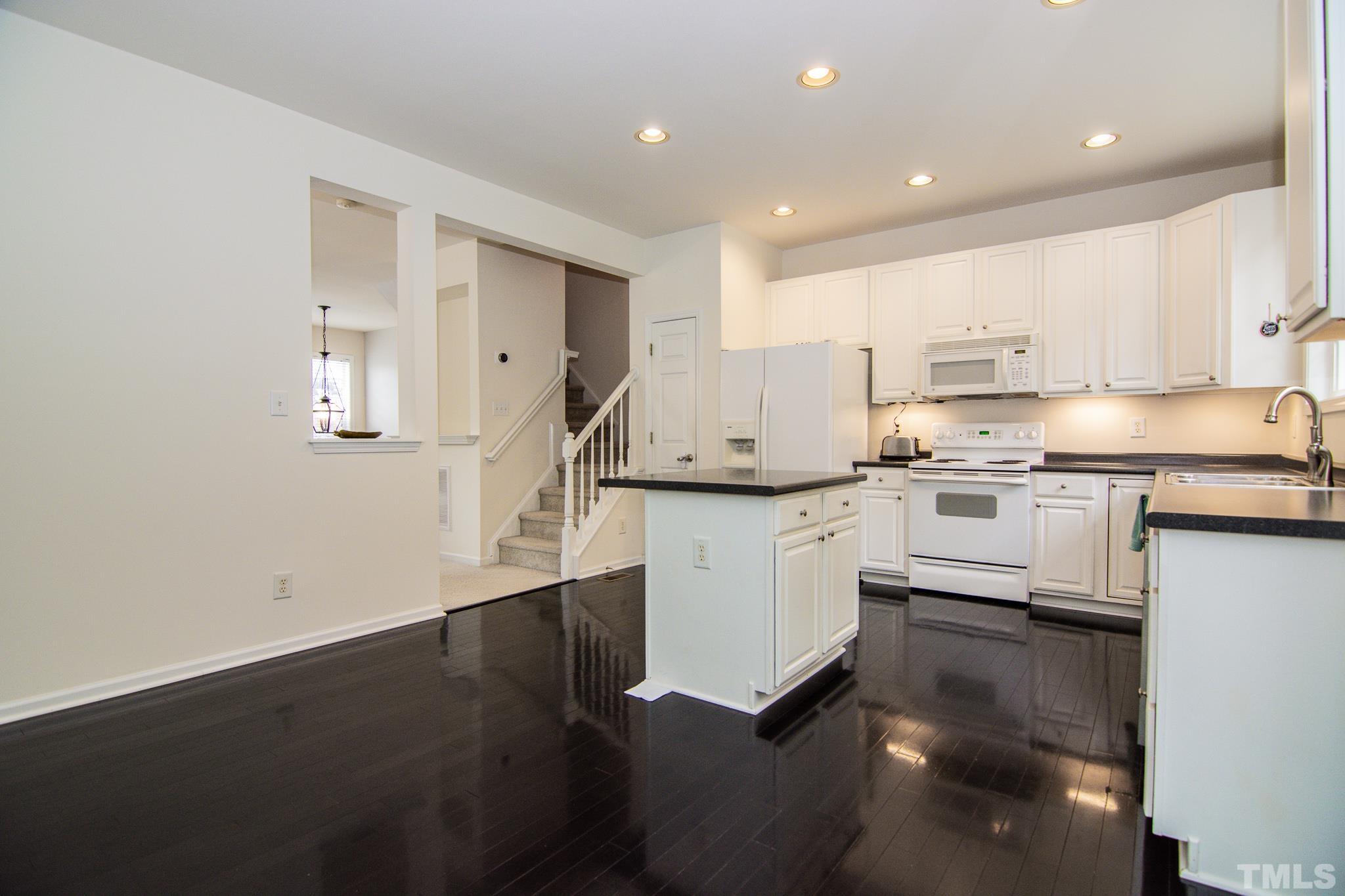 8120 Upper Lake Drive Raleigh, NC 27615 - Photo 8 of 29 a kitchen with white cabinets and appliances