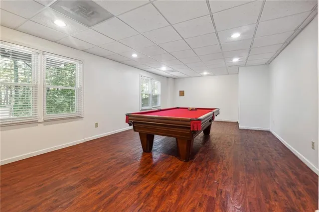 a room with pool table windows and wooden floor