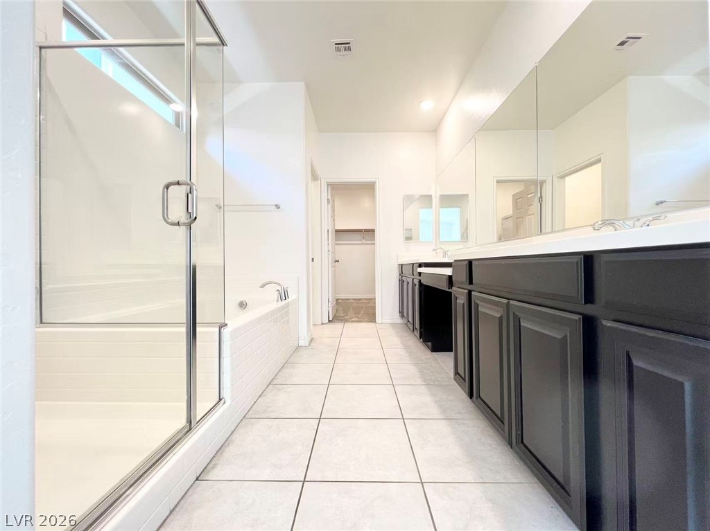 925 Bayberry Ridge Street Henderson, NV 89052 - Photo 9 of 27 Luxurious bathing retreat featuring a spacious walk-in shower and elegant double vanity.