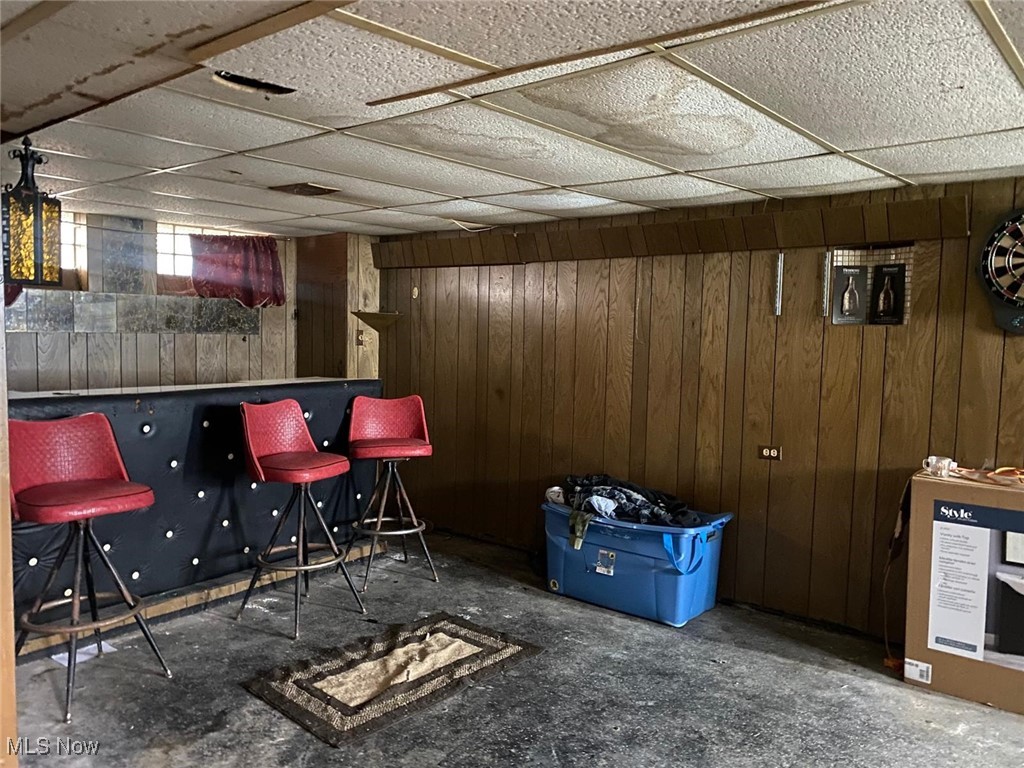 17011 Ridgeton Drive Cleveland, OH 44128 - Photo 23 of 35 Bar with wooden walls and a drop ceiling