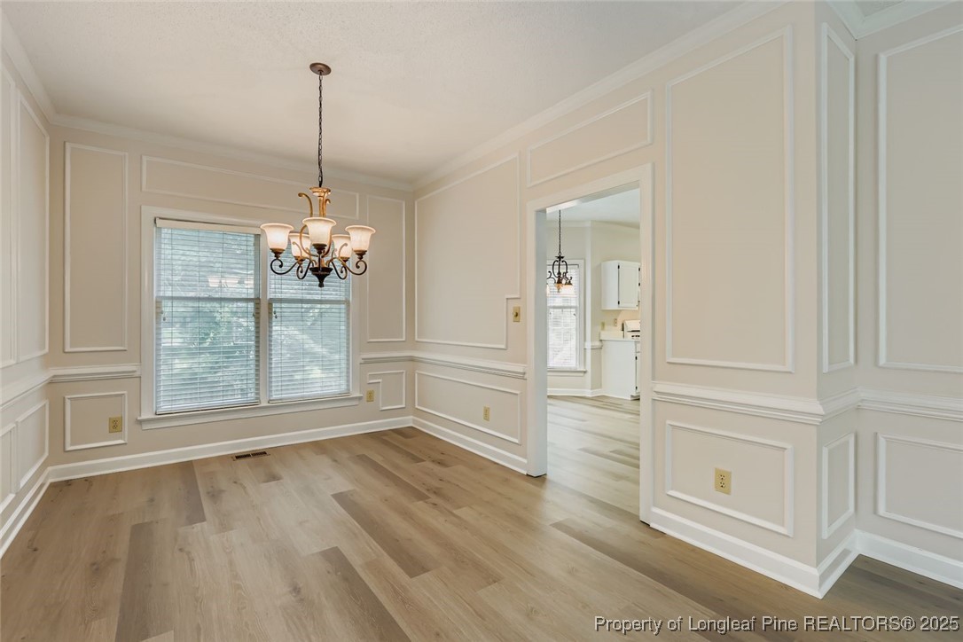 9012 Walking Stick Trail Raleigh, NC 27615 - Photo 6 of 28 a view of a room with wooden floor chandeliers and kitchen view