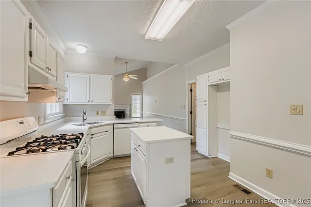 a kitchen with white cabinets and appliances