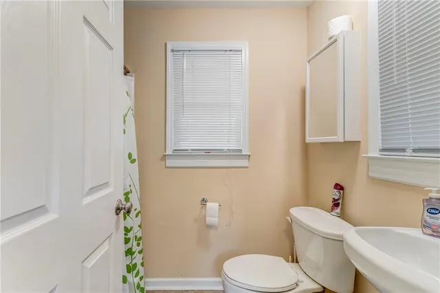 a bathroom with a toilet sink vanity and mirror