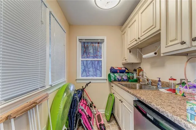 a kitchen with stainless steel appliances kitchen island granite countertop a table chairs and a chandelier