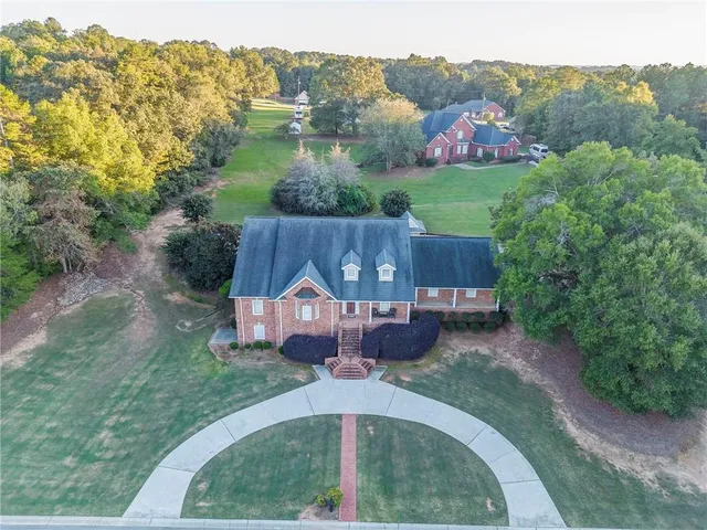 a front view of a house with a garden and trees