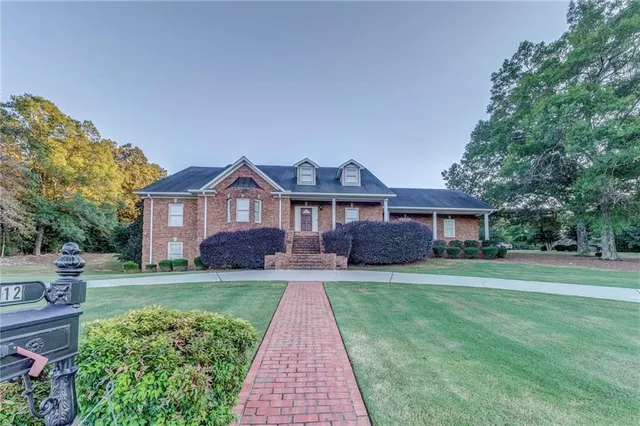 an aerial view of residential houses with outdoor space and trees