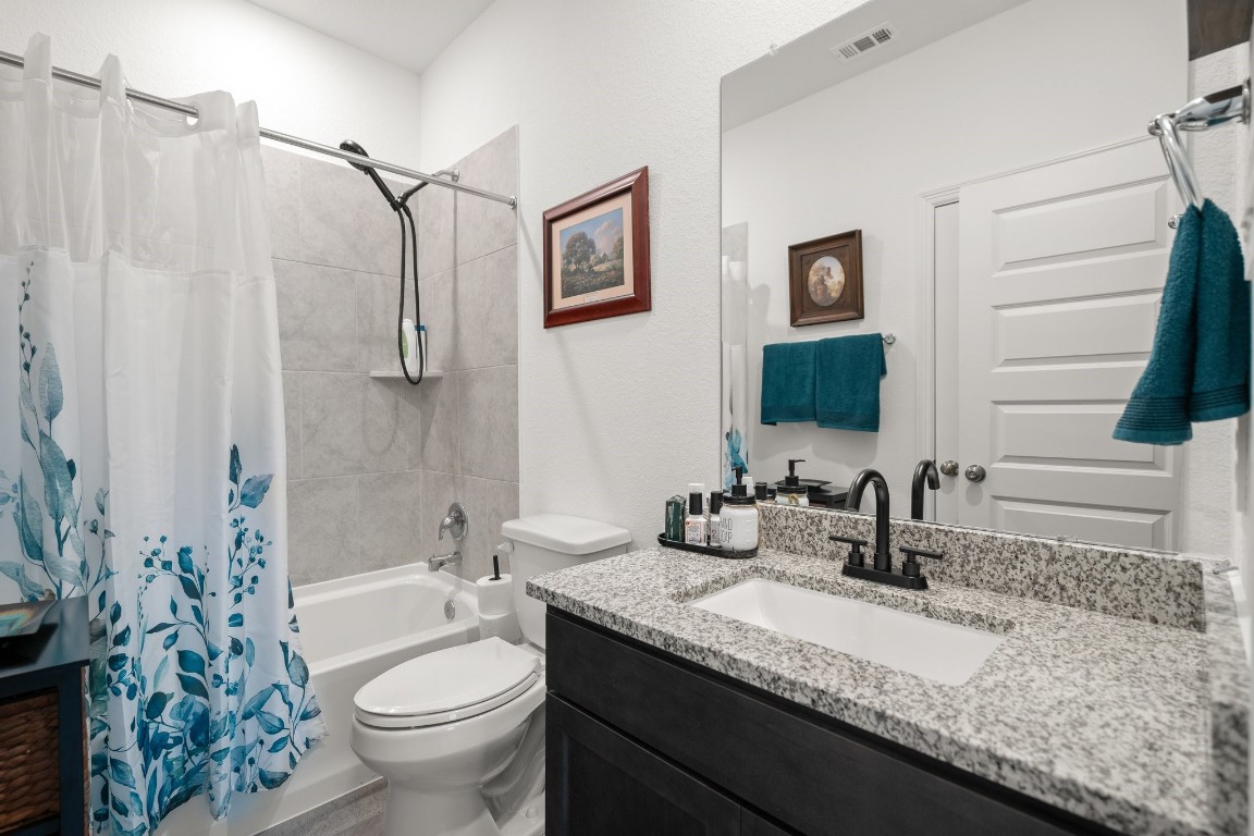 14449 Sunny Bend Way Conroe, TX 77303 - Photo 21 of 34 a bathroom with a granite countertop sink toilet and shower