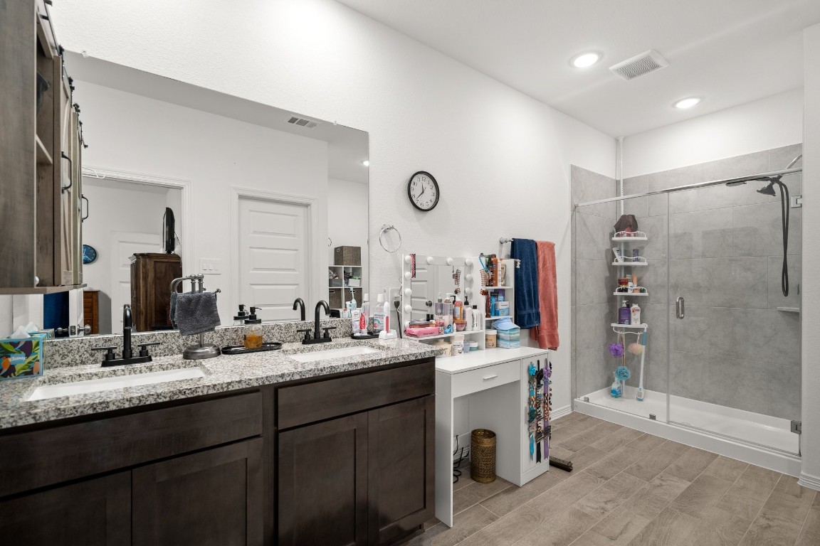 14449 Sunny Bend Way Conroe, TX 77303 - Photo 23 of 34 a bathroom with a sink double vanity and a shower