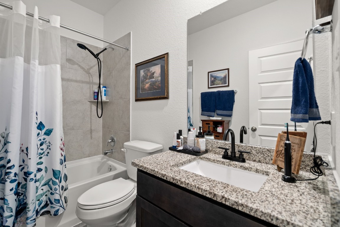 14449 Sunny Bend Way Conroe, TX 77303 - Photo 25 of 34 a bathroom with a granite countertop sink toilet and shower
