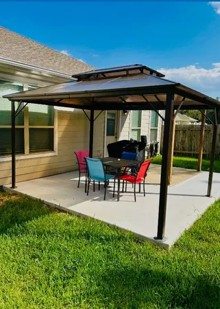 a view of a house with backyard and sitting area