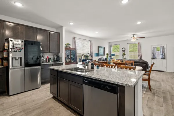 a large kitchen with granite countertop a large counter top stainless steel appliances and cabinets