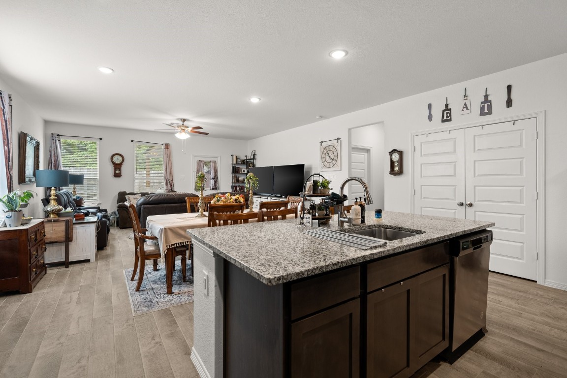 14449 Sunny Bend Way Conroe, TX 77303 - Photo 8 of 34 a view of kitchen island a sink wooden floor dining table and chairs