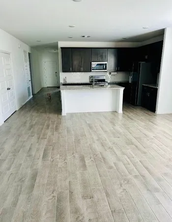 a view of kitchen with a sink microwave and cabinets