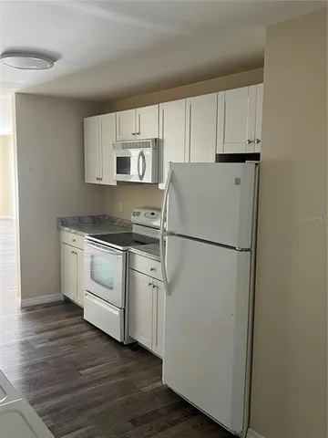 a kitchen with white cabinets and white appliances