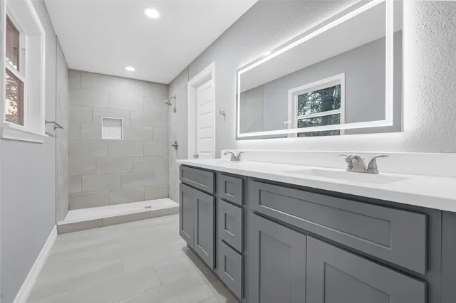 an empty room with wooden floor ceiling fan and windows