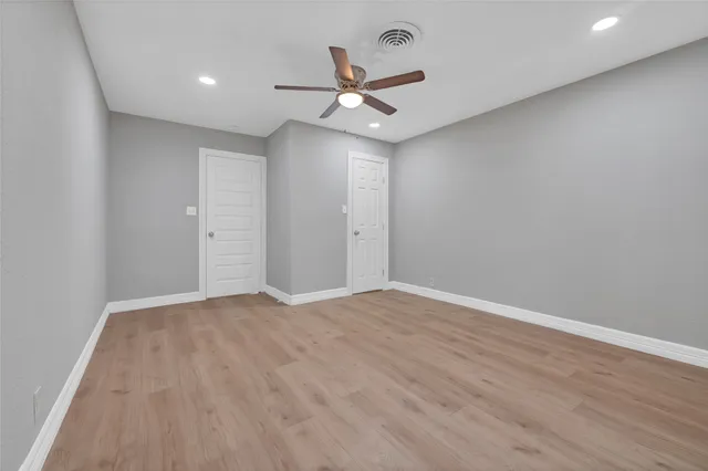 an empty room with closet and a ceiling fan